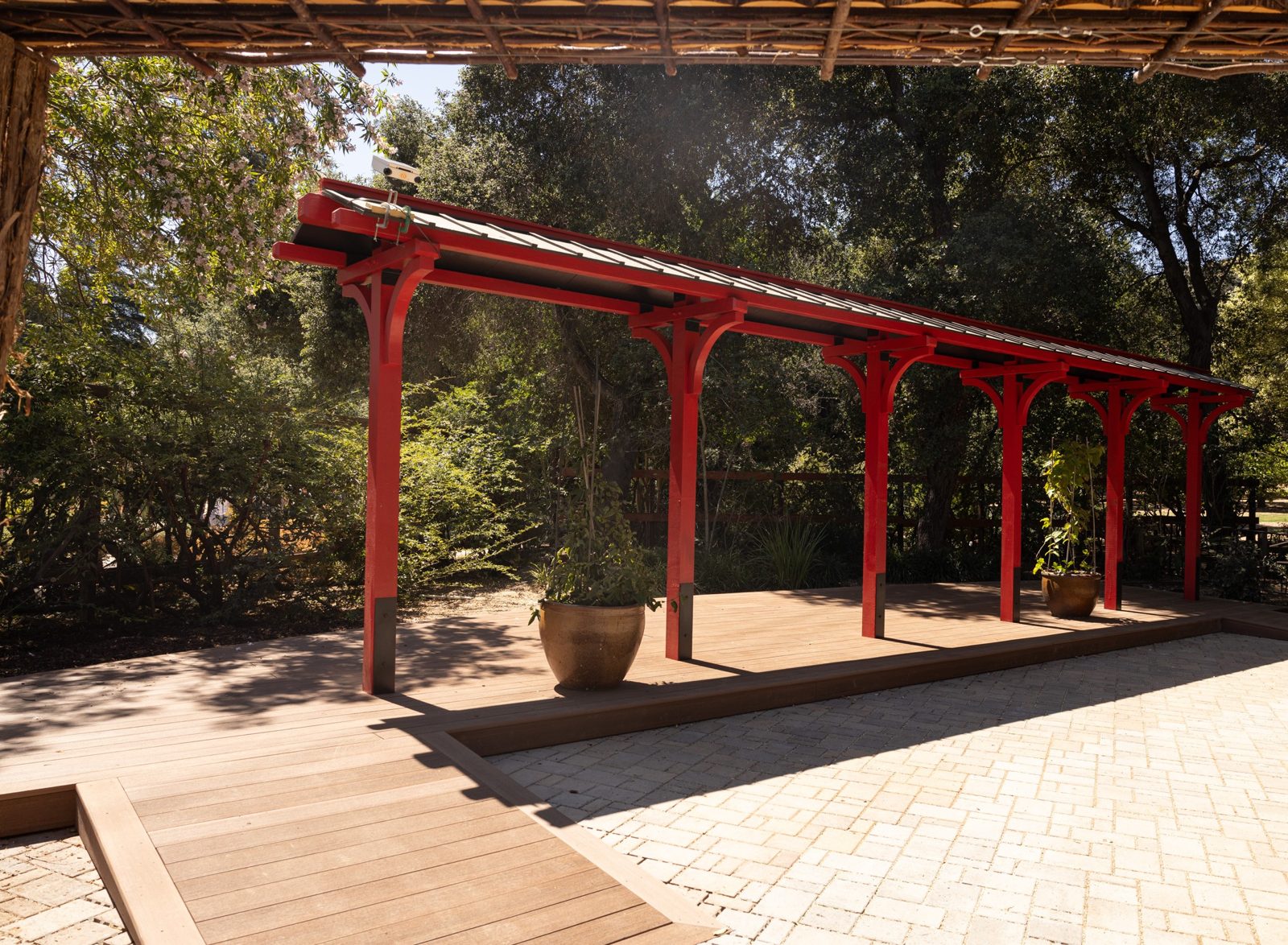 Completed red timber pavilion with standing seam roof and decking